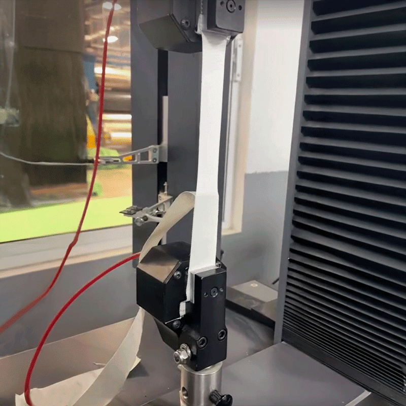 Mechanical adhesion peel test with a white strip, in an industrial setting